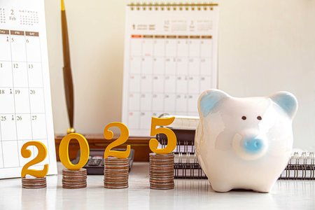 2025 New year saving money and financial planning concept. gold wooden number 2025 on a stack of coins for investment, and banking.の写真素材