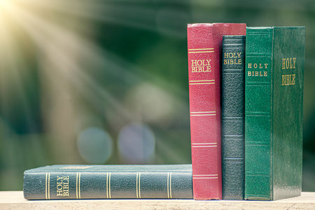 Bible on wooden table with twinkling light on green background. Christian concept use to learn about god.の写真素材