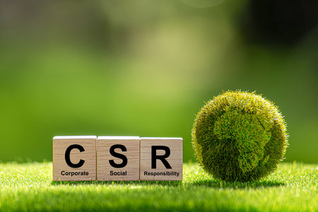 CSR (coporate social responsibility). words CSR on a woodblock and green world on a green background It is an idea for Corporate social responsibility and society activity concept.の写真素材