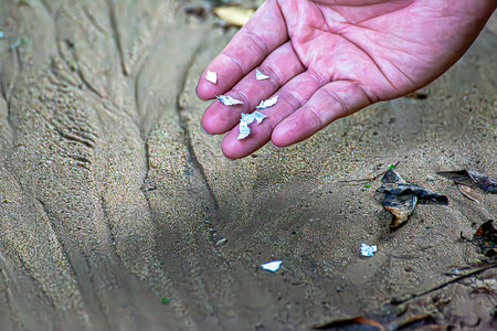 Macro shot of microplastics on a human finger. Concept of plastic pollution with nanoplastics. Soft...