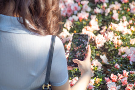 Woman holding phone on nature background with green background.