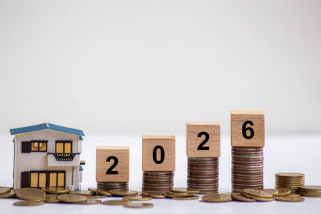 Financial coins stacked with wooden cubes of the year 2026 on a natural background. Piggy bank.
