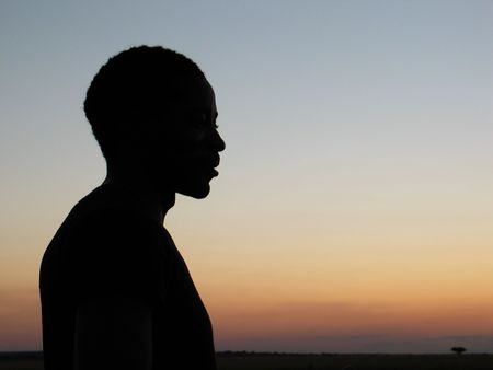 Sihouette of an African man against sunset in the savannah.の写真素材