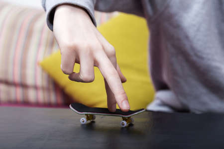 Boy is playing with his finger skateboard. Close up shot. Selective focus.の写真素材