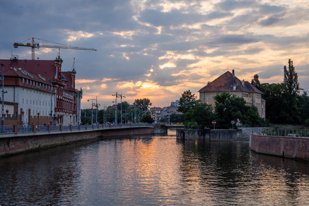 WROCLAW, POLAND - June 29, 2021: A sunset over Odra river, viewed from Piaskowy Bridge. Historical medieval architecture in background.のeditorial素材