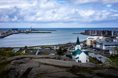 HAFNARFJORDUR, ICELAND - July 16, 2021:
A city landscape from a rocky hill in Hafnarfjordur, Green...
