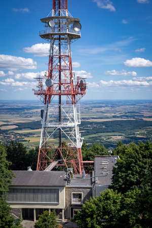 SLEZA, POLAND - August 07, 2021:  Radio and TV mast, surrounded with trees, on the top of Sleza mountain, Sudetes Foreland. Sunny summer day, blue sky.のeditorial素材