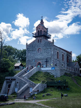 SLEZA, POLAND - August 07, 2021:  A historical Catholic church, surrounded with trees, on the top of Sleza mountain, Sudetes Foreland. Sunny summer day, blue sky.のeditorial素材