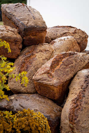 Loaves of a fresh artisan bread. 
Close-up of a pile of rectangular loaves of bread, made using natural methods and ingredients.の写真素材