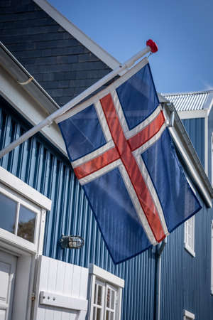 Hafnarfjordur, Iceland - July 17, 2021:
Icelandic flag on a blue building of Hafnarfjordur museum. Sunny day, blue sky.のeditorial素材