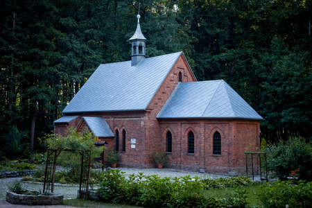 Trzebnica, Poland - August 29, 2021: A neo-gothic, brick church of the Fourteen Holy Helpers, surrounded with the forest.のeditorial素材