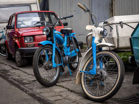 Wroclaw, Poland - September 19, 2021:
Two vintage blue Komar motorcycles and a red 126 Fiat car.のeditorial素材