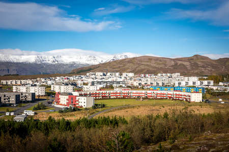 Reykjavik, Iceland - October 1, 2021:
Panorama of Reykjavik suburbs, Iceland. Big round residential building, Ulfarsfell hill and snowy Mount Esja in background.のeditorial素材