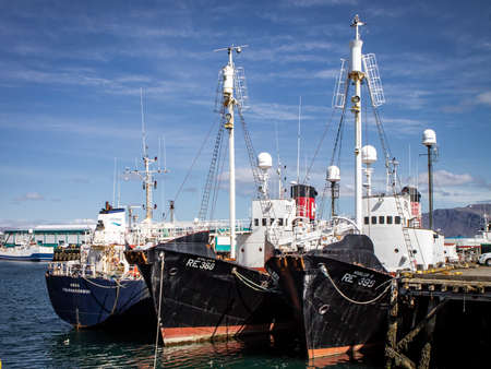 Reykjavik, Iceland - June 12, 2021: Three black fish cutters moored at a pier in Old Reykjavik Harbor, on a bright sunny day.のeditorial素材