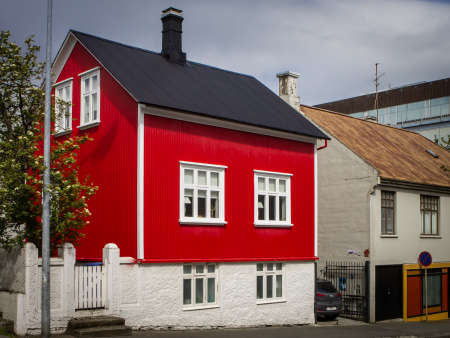 Reykjavik, Iceland - July 11, 2021: A red, traditional icelandic wooden house. Cloudy sky. No people.のeditorial素材