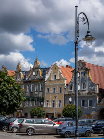 Niemcza, Poland - July 9, 2021: Historical residential houses and cars parked in the town main square. Summer day, no people.のeditorial素材