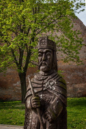 Leczyca, Poland - May 10, 2021: A wooden king figure in front of a medieval Royal Castle.のeditorial素材