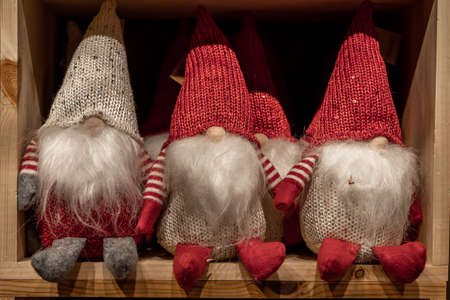 Three Christmas dwarfs with long white beards, sitting on the shelf.の写真素材
