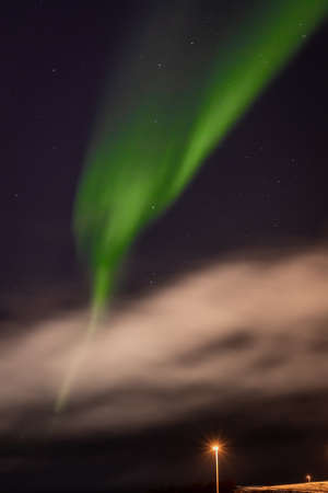 Green northern lights over Hafnarfjordur town, Iceland. Winter night, no people.の写真素材