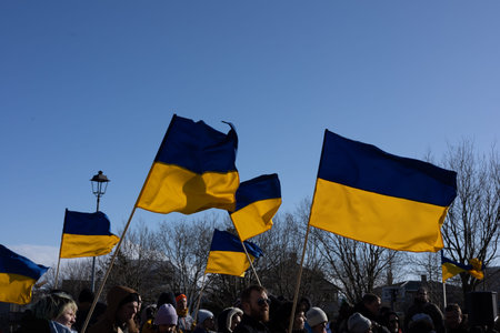 Reykjavik, Iceland - March 13, 2022: Ukrainian flags carried by people protesting against war in...