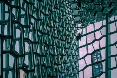 Reykjavik, Iceland - March 23, 2022: A steeplejack cleaning windows inside Harpa concert hall....