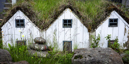 Three small white wooden elf houses with grass roof, typical for Iceland.の写真素材