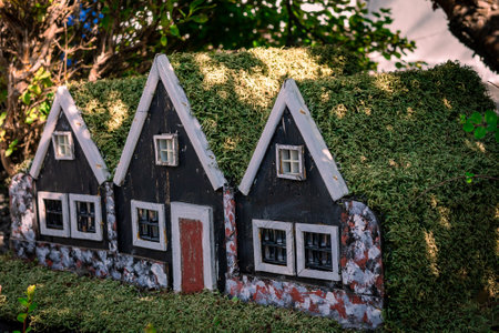 Three small black wooden elf houses with green moss roof, typical for Iceland.の写真素材