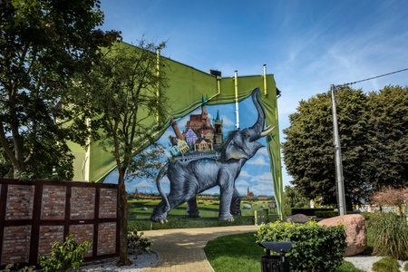 Trzebiatow, Poland - September 18, 2023: Green mural with elephant on the wall in historical city center.のeditorial素材