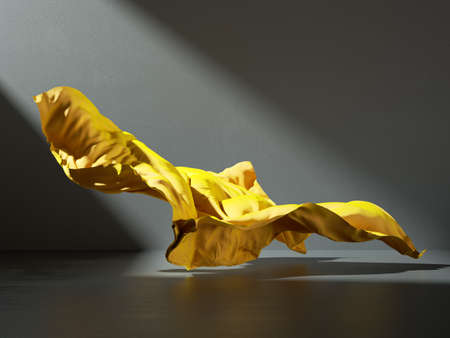3d render. Abstract fashion background with yellow fabric cloth falling on the floor inside the dark room illuminated with ray of light. Silk textile is blown away by the windの写真素材