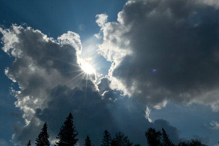 Beam of light through the clouds. Rays of light shining through dark clouds , dramatic sky with cloud.の写真素材