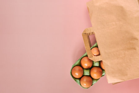 Kraft bag with chicken eggs in tray on beige background, shopping concept, space for text.の写真素材