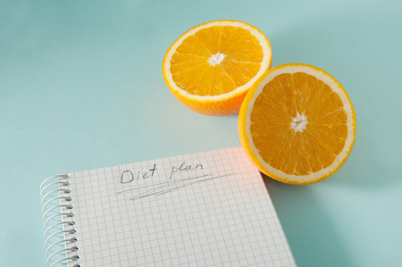 Writing a Diet Plan on a blue background with orangesの写真素材