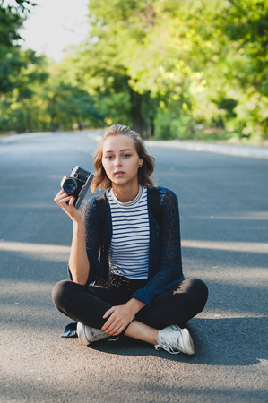 Teenage girl with photo camera on the roadの写真素材