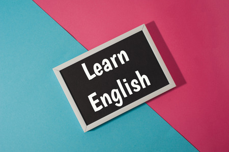 Learn English - text on chalkboard on blue and pink bright background.の写真素材