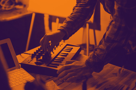 Midi keyboard and laptop - the process of recording sound and music. Duotone effect - orange and purple colorsの写真素材