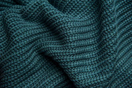 Texture of a woolen knitted green-blue sweater. Fabric turquoise background. Beautiful saturated...