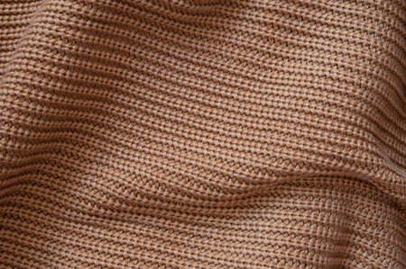 Texture of a woolen knitted brown sweater. Fabric background.の写真素材