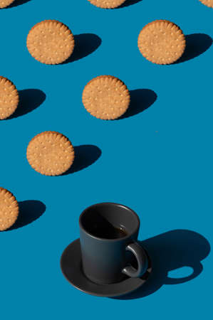 Collage pattern of cookies and a cup of espresso coffee on a blue background. Minimal sunlight conceptの写真素材