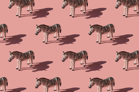 Pattern made with zebra toy on pink background. Trendy minimal picture with hard sunlight shadows.の写真素材