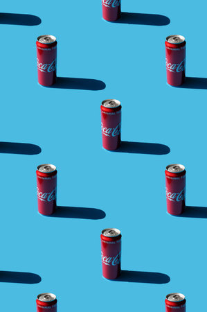 Krakow, Poland - 13 May 2021. Pattern of Coca-Cola on blue background. Classic Coca-Cola can Original taste.のeditorial素材
