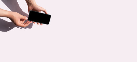 Mockup Hands holding smartphone on gray background with place for text. Minimal conceptの写真素材