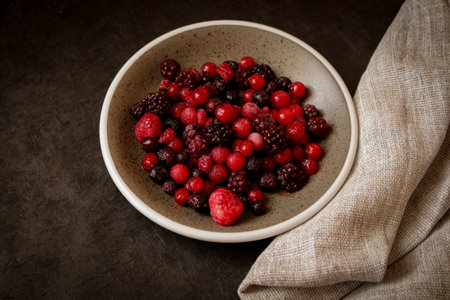 A ceramic bowl filled with frozen mixed berriesの写真素材