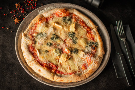 Freshly baked pizza topped with different cheeses, tomato sauce, and grated Parmesanの写真素材