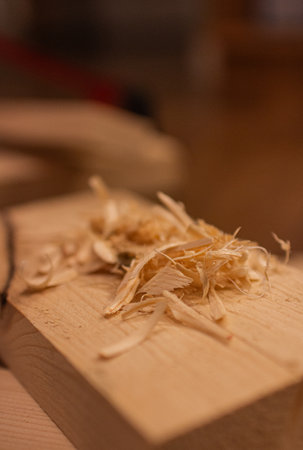 A pile of wood shavings rests on a wooden plankの写真素材