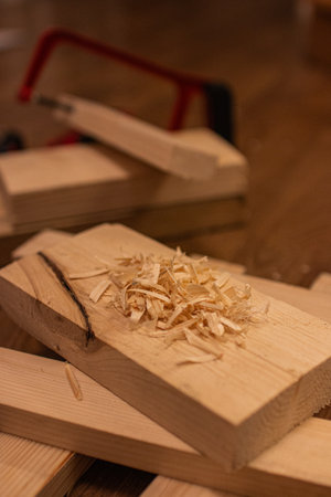 A pile of wood shavings rests on a wooden plankの写真素材