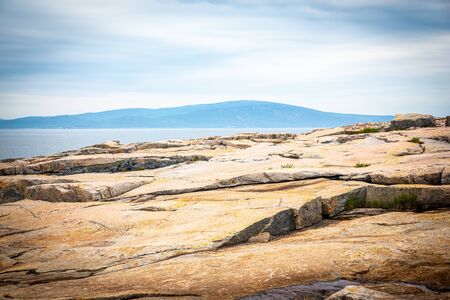View of Cadillac Mountain with granite in foreground from Schoodic Point in Acadia National Park, Maine, USAの写真素材