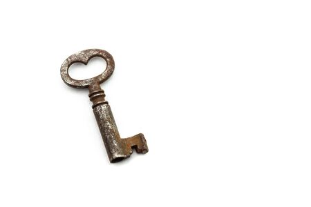 Small old rusty antique key on white background with heart-shaped holeの写真素材