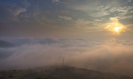 beautiful orange sunset in blue green cloudy sky from mountain with elctricity tower in the middleの写真素材