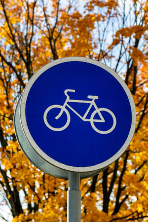Blue and white bicycle lane sign indicating bike route, large round roadside traffic signage.の写真素材