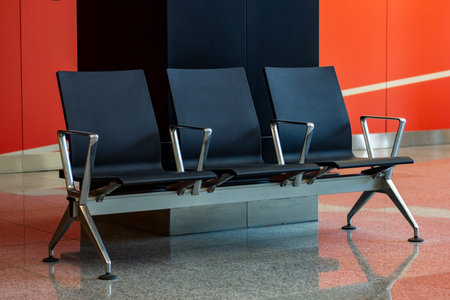 Empty black seats in the waiting hall in the airport.